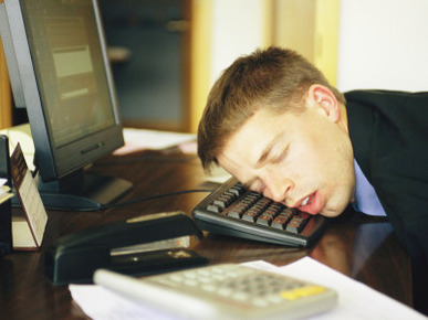 A Man Sleeps with His Head on His Computer Keyboard
