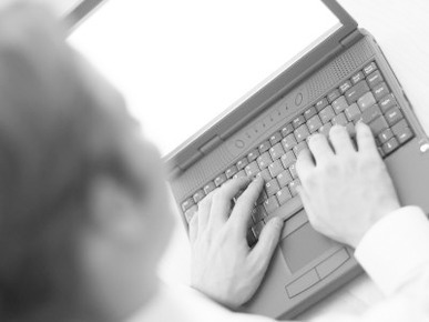 Caucasian Business Man Typing on Black Laptop Computer