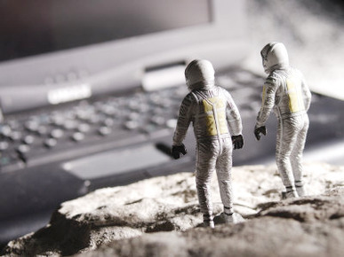 Model Astronauts Looking at Giant Laptop Computer on the Moon