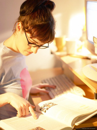 Young Woman Studying in Front of Computer at Her Desk
