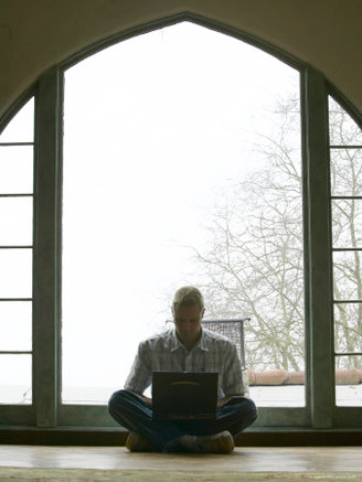 Male Young Adult Sitting on Floor Using Laptop Computer