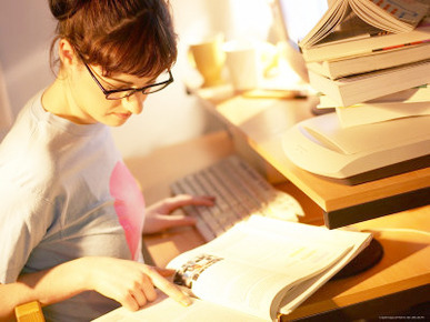 Young Woman Studying in Front of Computer at Her Desk