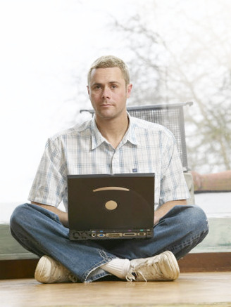 Male Young Adult Sitting on Floor Using Laptop Computer
