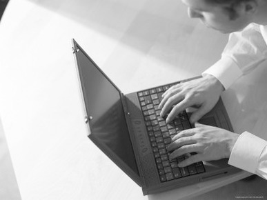 Caucasian Businessman Typing on Black Laptop Computer