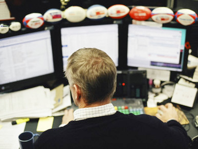 Businessman Working on His Desk with Three Computer Monitors