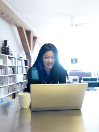 Asian Woman Works on Her Computer in the Morning