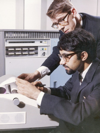 Two Technicians Check a Computer Printout
