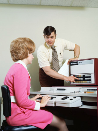 Man Helping Woman With Data Entry Computer